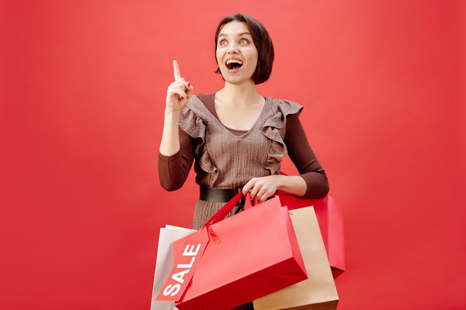 Cheerful woman with shopping bags celebrating a sale on a vibrant red backdrop.